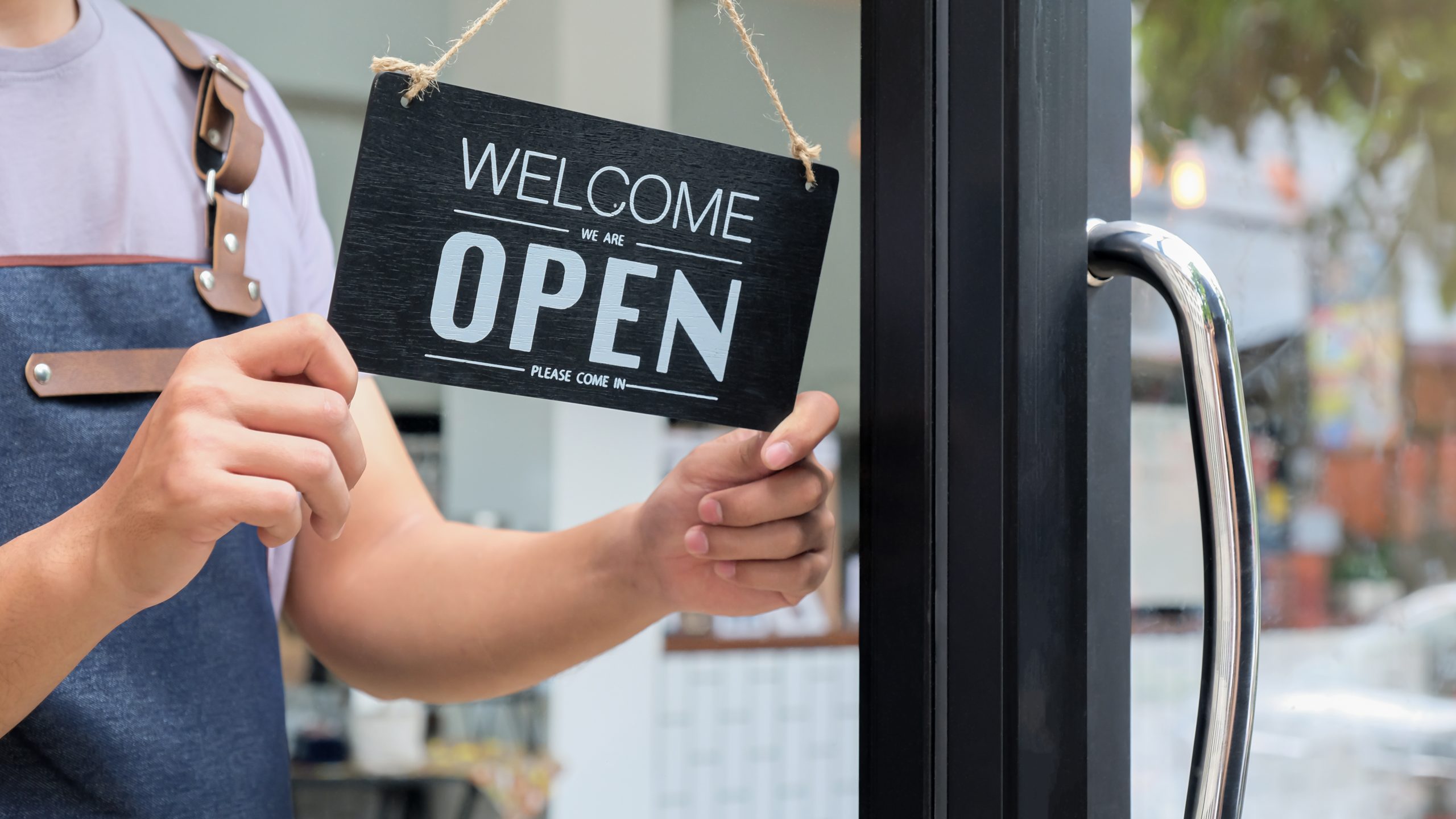 Cropped shot of Business owners hold an Open sign to provide service.